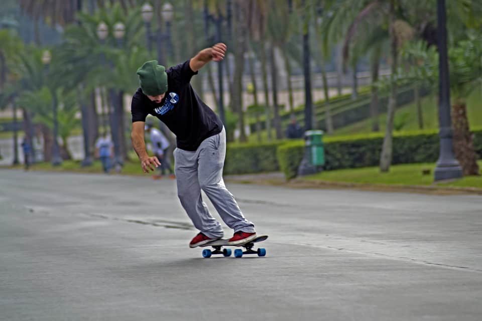 man wearing bonnet riding a longboard